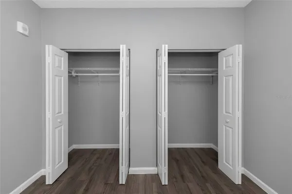 a view of empty room with wooden floor and closet