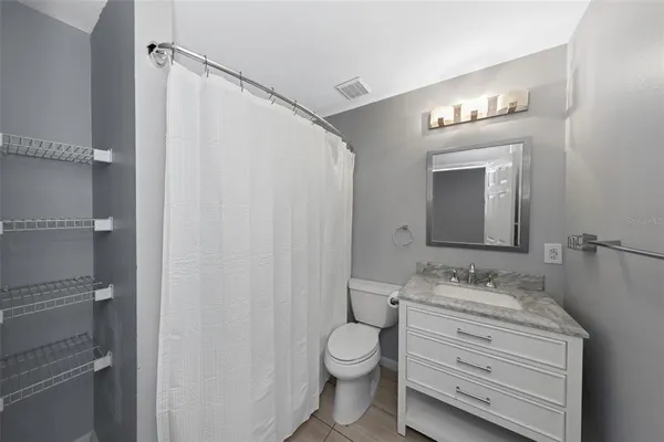 a bathroom with a toilet a sink a vanity and mirror