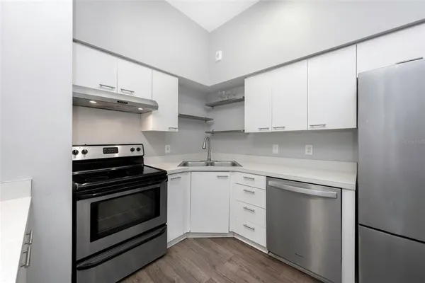 a kitchen with stainless steel appliances white cabinets and a stove top oven