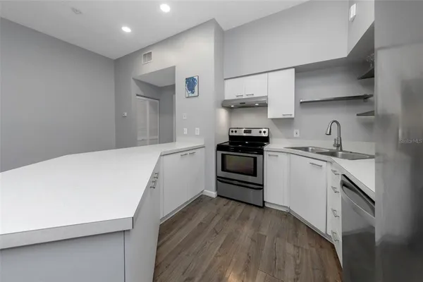 a kitchen with stainless steel appliances a white cabinets and sink