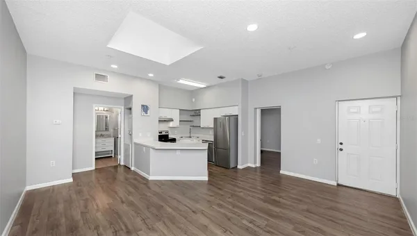 a view of a kitchen with stainless steel appliances refrigerator sink and cabinets