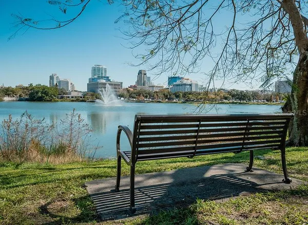 a view of a bench in the garden near a lake