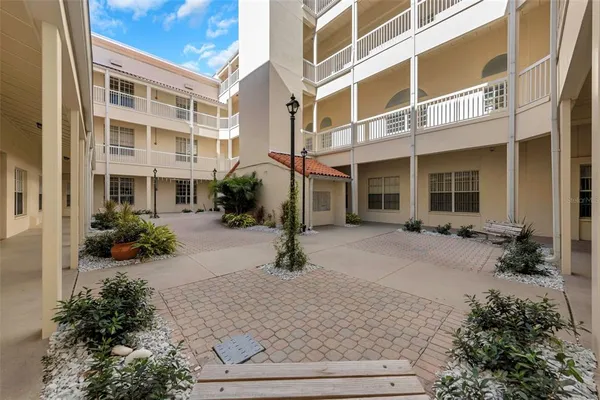 front view of a brick house with a yard and potted plants