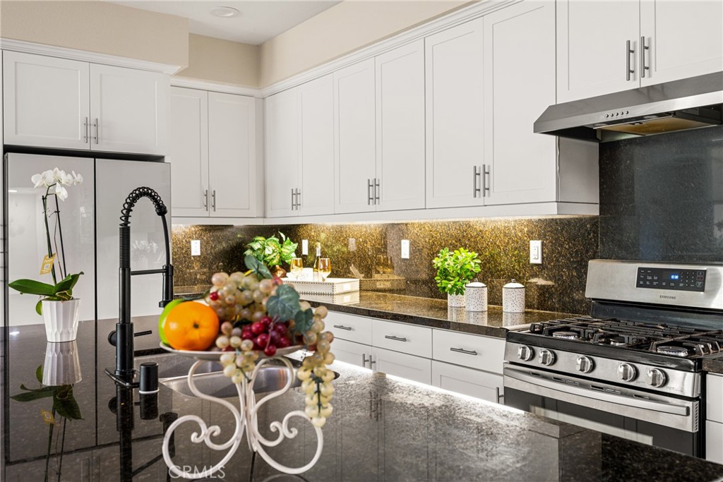 228 Borrego Irvine, CA 92618 - Photo 14 of 50 a kitchen with stainless steel appliances granite countertop a stove a sink and a refrigerator