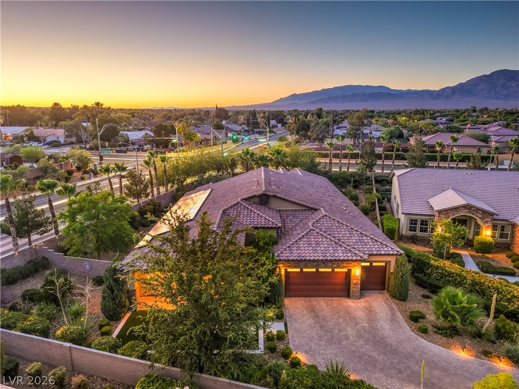 7119 Arabian Ridge Street Las Vegas, NV 89131 - Photo 3 of 73 An aerial perspective reveals a beautiful home and a landscaped yard, set against a distant mountain range.