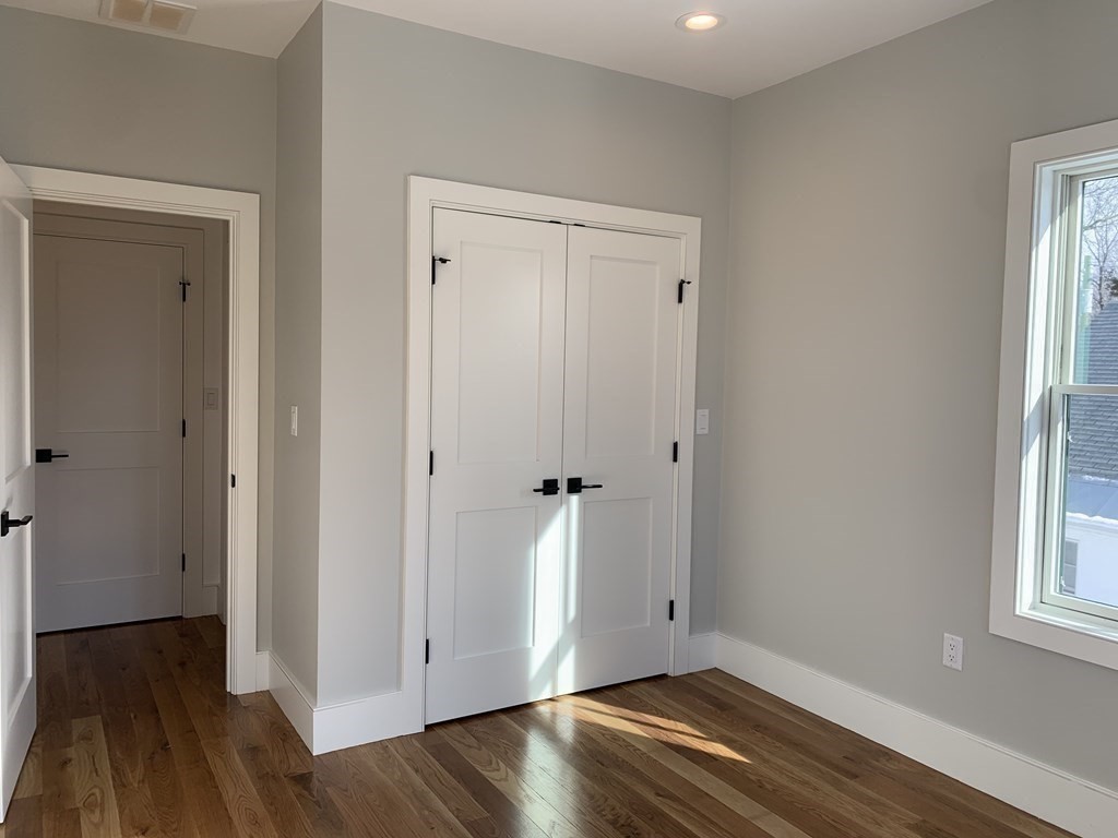 7 Sharon Avenue, Unit 7 Newton, MA 02466 - Photo 13 of 28 a view of an empty room with wooden floor and a window