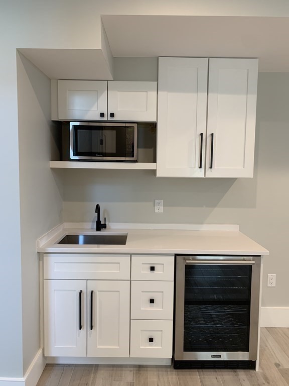 7 Sharon Avenue, Unit 7 Newton, MA 02466 - Photo 22 of 28 a kitchen with stainless steel appliances granite countertop a stove a microwave and a sink