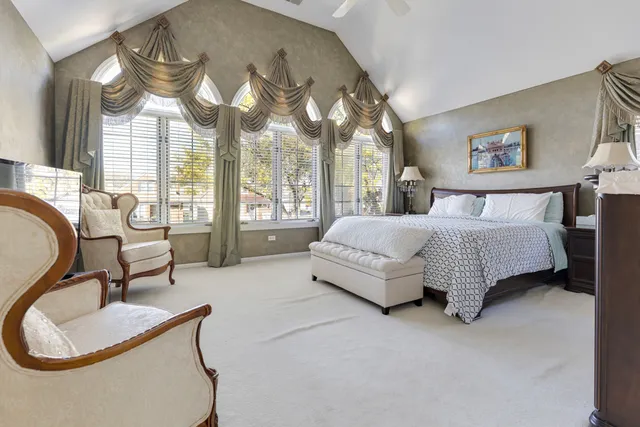 a spacious bedroom with a bed and glass walk in closet