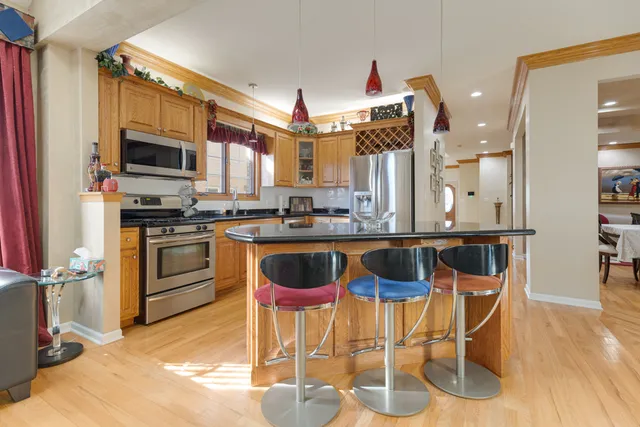 a kitchen with stainless steel appliances kitchen island granite countertop a stove a sink and a microwave