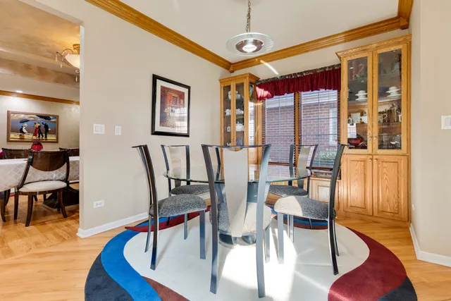 a dining room with wooden floor a glass table and chairs
