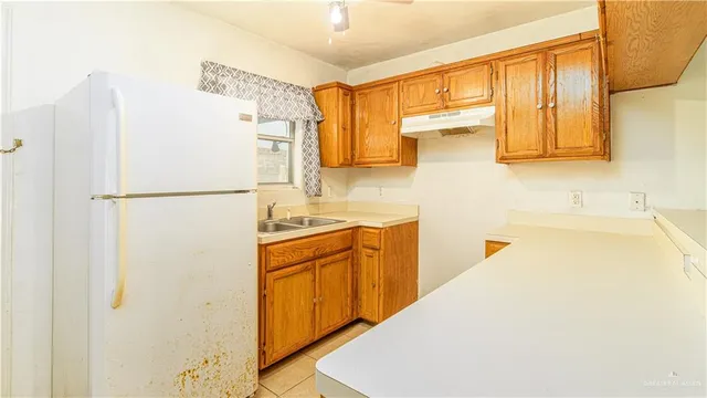 a kitchen with a refrigerator a sink and cabinets