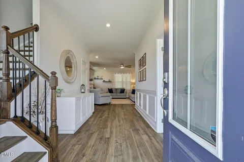 a hallway with white cabinets and wooden floor