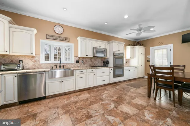 a large kitchen with stainless steel appliances granite countertop a sink and cabinets