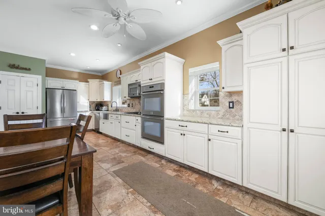 a kitchen with granite countertop white cabinets stainless steel appliances and a sink