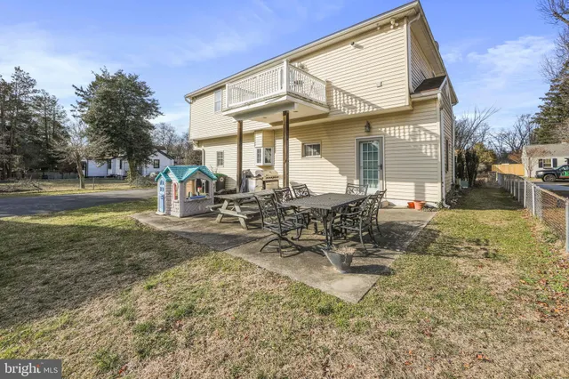 a view of a white house with a yard and sitting area