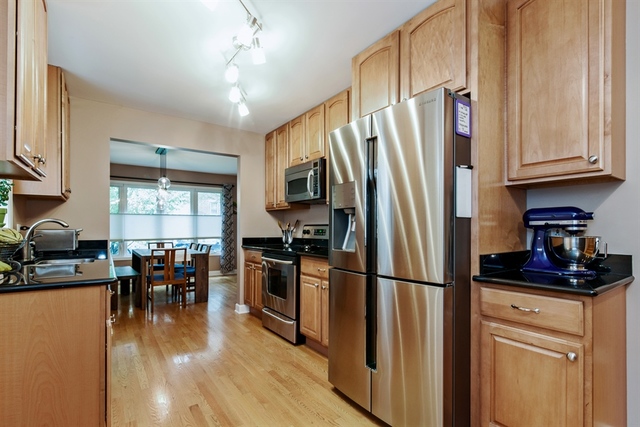 1425 Brummel Street Evanston, IL 60202 - Photo 7 of 24 a kitchen with granite countertop a refrigerator a stove a sink a dining table and chairs with wooden floor