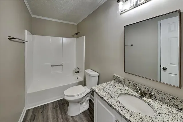 a bathroom with a granite countertop sink toilet a mirror and shower