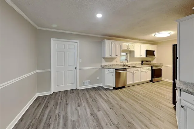a kitchen with stainless steel appliances granite countertop a stove top oven and cabinets