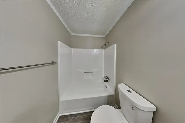 a white toilet sitting next to a bath tub