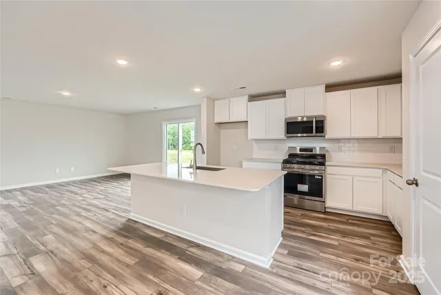 a kitchen with kitchen island a sink stainless steel appliances and cabinets