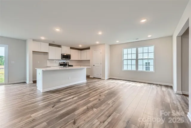 a view of kitchen with wooden floor and electronic appliances