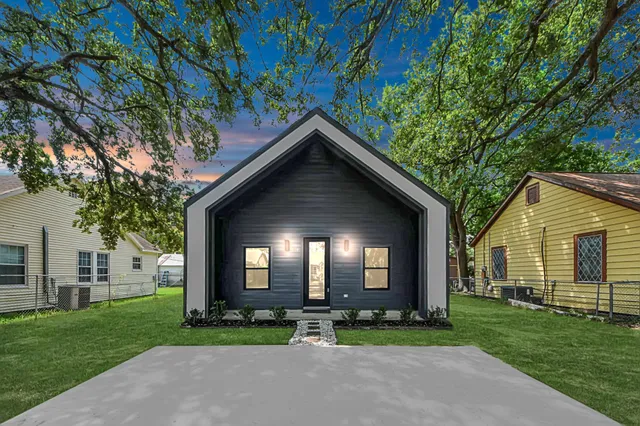 a front view of a house with a yard and trees