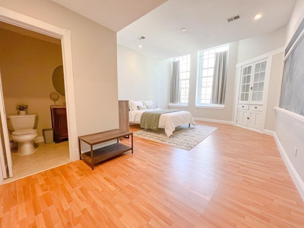 31 Elizabeth Street, Unit 202 Worcester, MA 01605 - Photo 11 of 12 a spacious bedroom with a bed a couch and a large window