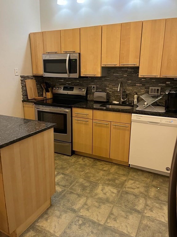 31 Elizabeth Street, Unit 202 Worcester, MA 01605 - Photo 4 of 12 a kitchen with stainless steel appliances a stove a sink and a microwave