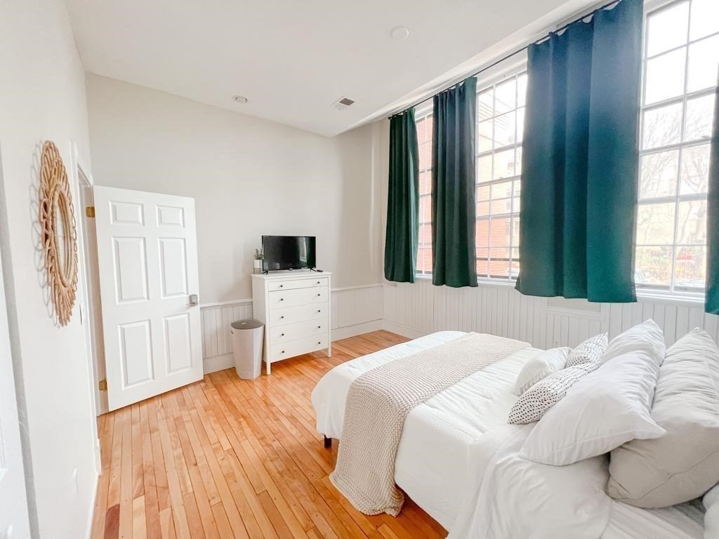 31 Elizabeth Street, Unit 202 Worcester, MA 01605 - Photo 8 of 12 a bedroom with a bed and a flat screen tv
