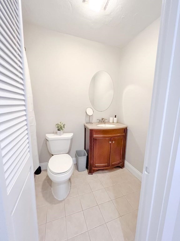 31 Elizabeth Street, Unit 202 Worcester, MA 01605 - Photo 9 of 12 a bathroom with a toilet a sink and a mirror