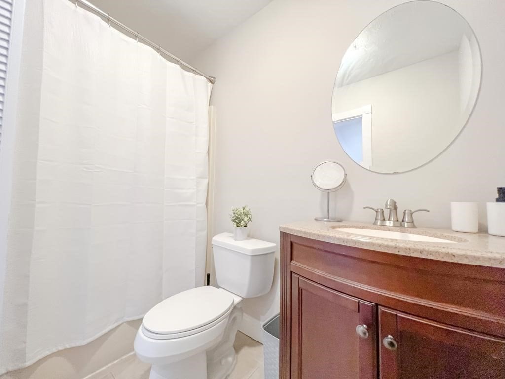 31 Elizabeth Street, Unit 202 Worcester, MA 01605 - Photo 10 of 12 a bathroom with a toilet a sink a mirror and vanity