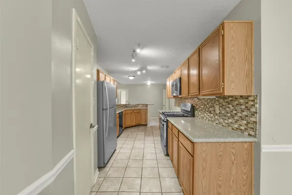 a kitchen with stainless steel appliances granite countertop a sink and a refrigerator