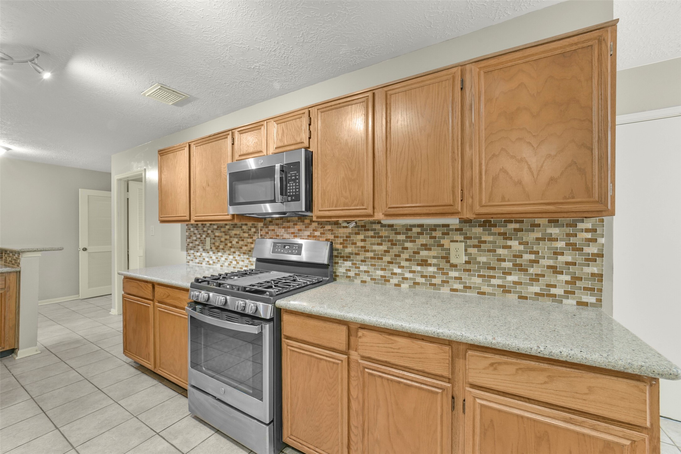 5539 Rivertree Lane Spring, TX 77379 - Photo 19 of 25 a kitchen with stainless steel appliances granite countertop white cabinets and window