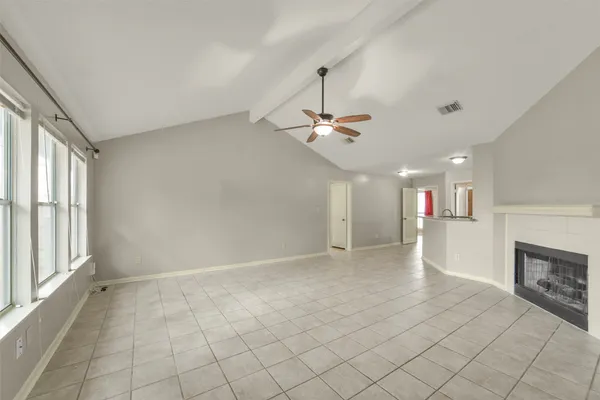 an empty room with windows and fireplace