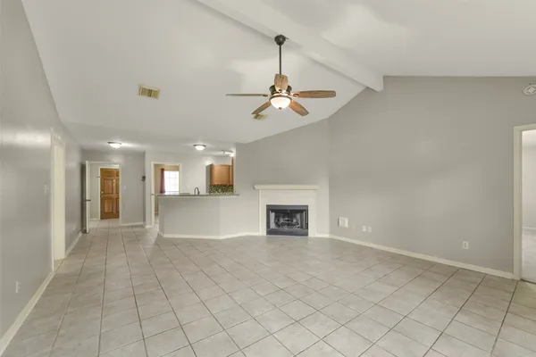 an empty room with fan and windows
