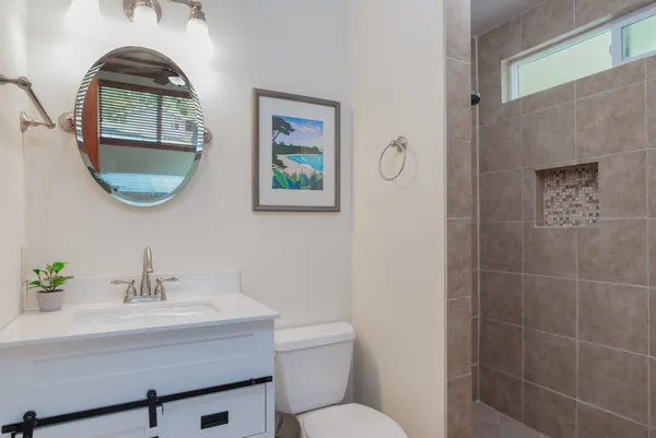 a bathroom with a toilet a sink and mirror