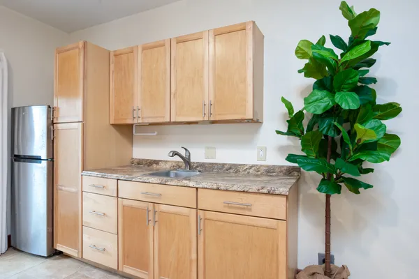 a view of kitchen with stainless steel appliances granite countertop white cabinets