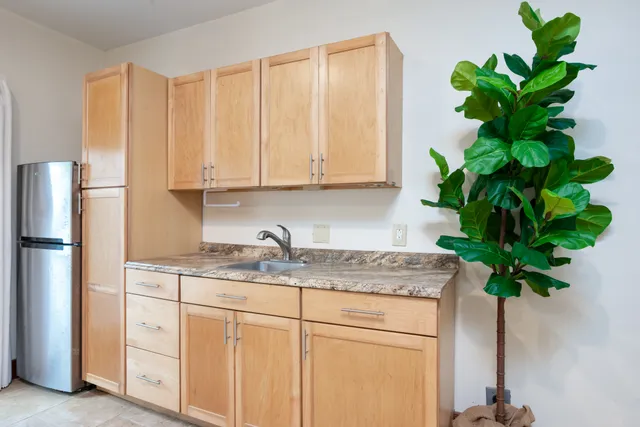 a view of kitchen with stainless steel appliances granite countertop white cabinets