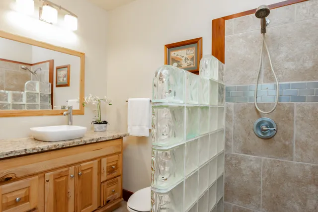a bathroom with a granite countertop sink and a mirror