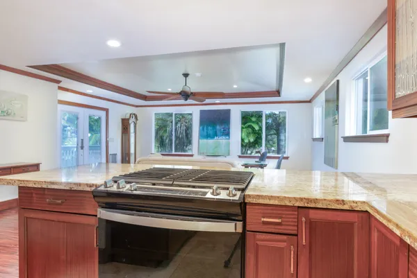 a kitchen with kitchen island granite countertop a stove and a sink