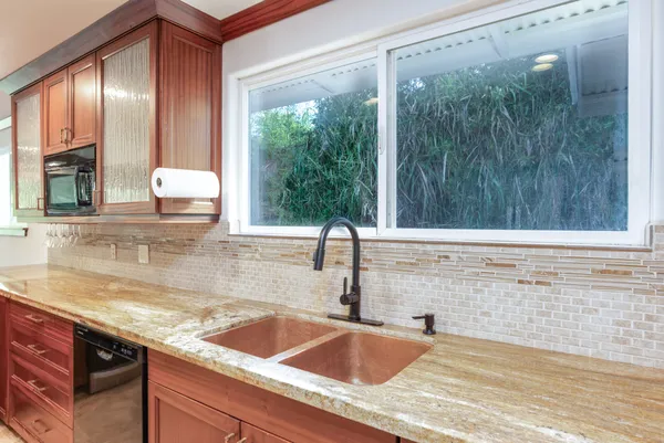 a bathroom with a granite countertop sink and a mirror