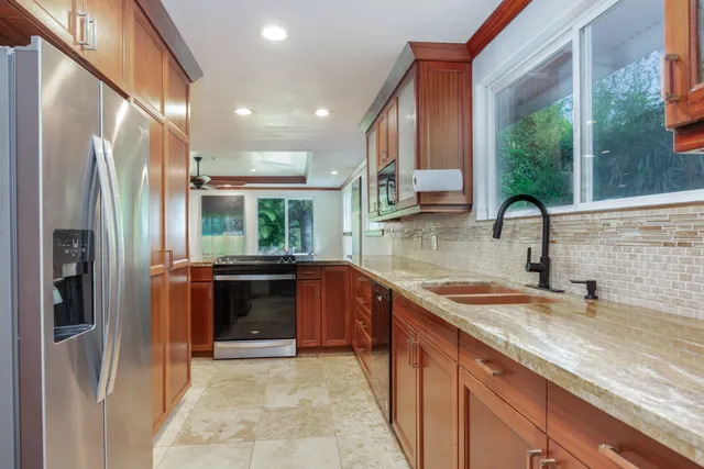 a kitchen with stainless steel appliances granite countertop a refrigerator and a sink