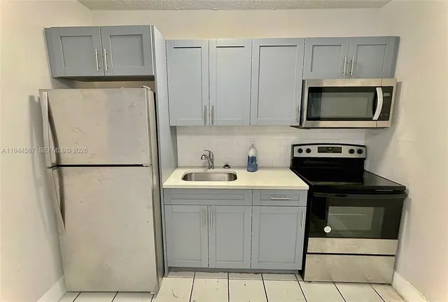 a kitchen with a sink and a refrigerator