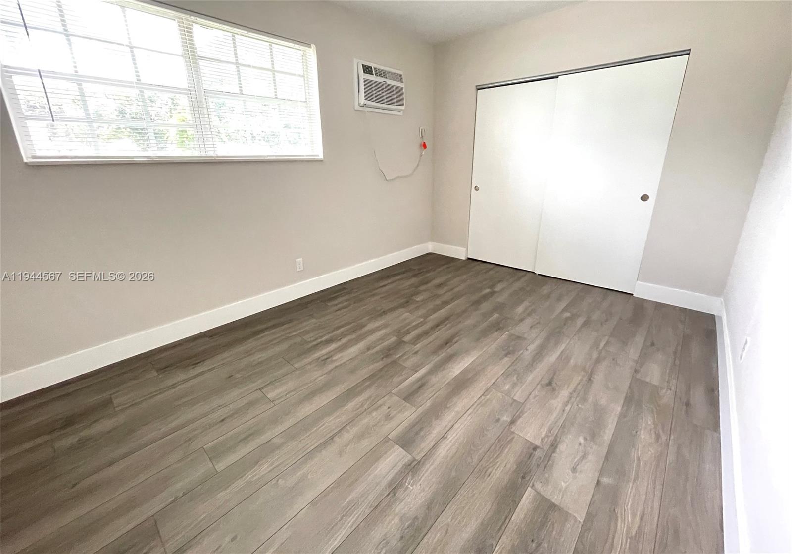 2580 Northwest 4th Court Pompano Beach, FL 33069 - Photo 6 of 10 an empty room with wooden floor and windows