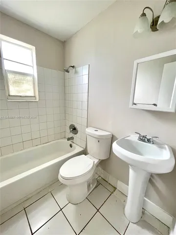 a bathroom with a sink toilet mirror and bathtub