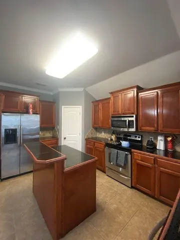 a kitchen with stainless steel appliances granite countertop a sink a stove and a refrigerator