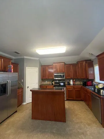 a kitchen with stainless steel appliances and a stove top oven