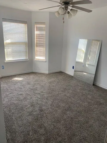 a view of a livingroom with a ceiling fan and window