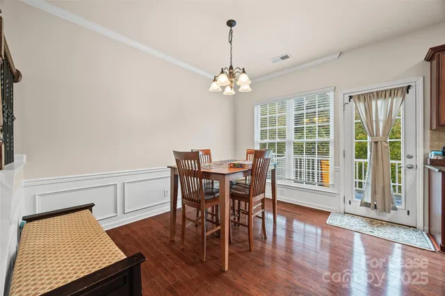 a view of a dining room with furniture wooden floor and chandelier