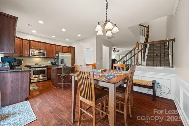 a kitchen with stainless steel appliances granite countertop wooden cabinets a refrigerator a stove a sink and dishwasher